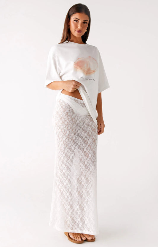 A woman wearing white top and pink skirt from Peppermayo's women's bottoms collection